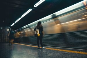 mulher esperando o metrô na plataforma de embarque
